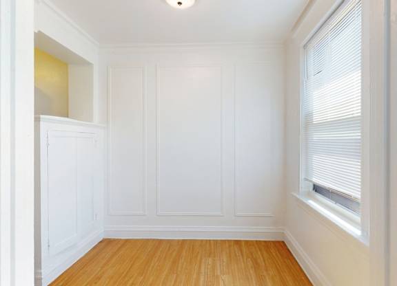 A room with white walls and wooden flooring.