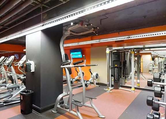 A gym with treadmills, weights, and exercise equipment.