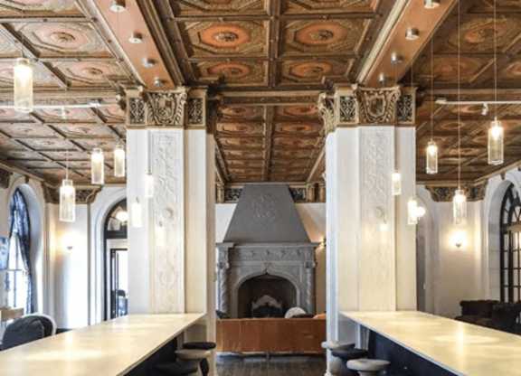 A room with a fireplace and a row of stools.