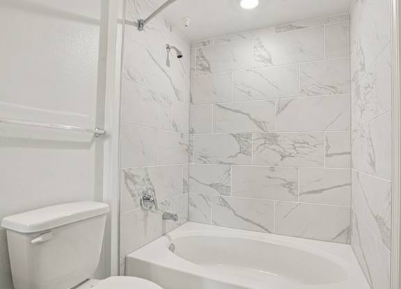 A white toilet and sink in a bathroom.