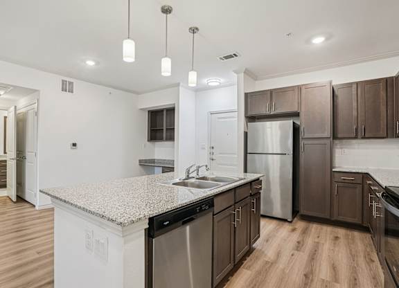 A kitchen with a granite countertop and stainless steel appliances.