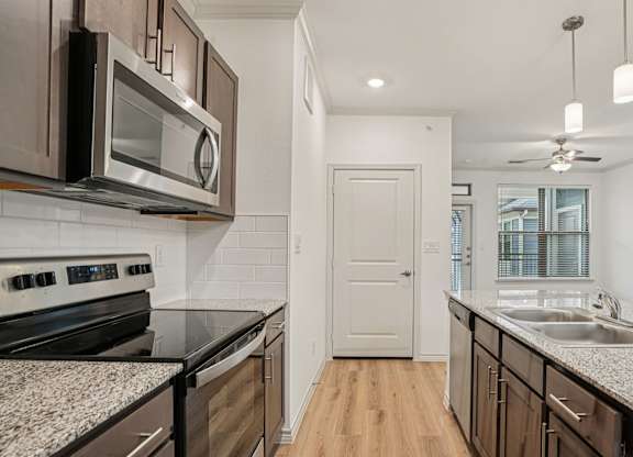 A kitchen with a black counter top and a white door.