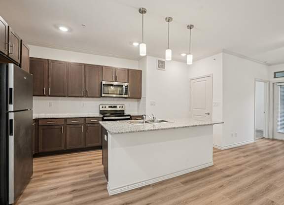 A kitchen with a white island and wooden floors.