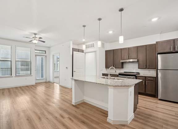 A kitchen with a white island and stainless steel appliances.