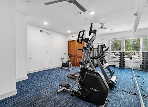 A spartan room with a treadmill and exercise bike.