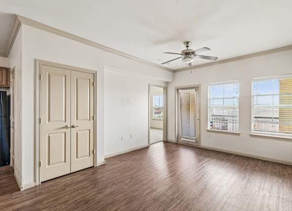 A room with a ceiling fan and wooden floors.