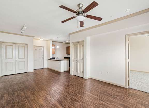 A room with a ceiling fan and wooden floors.