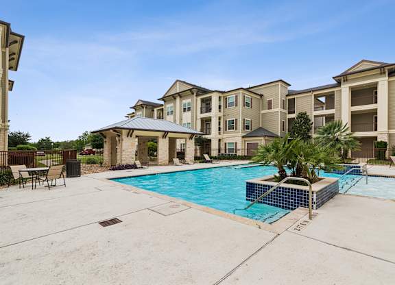 A pool in front of apartment buildings.
