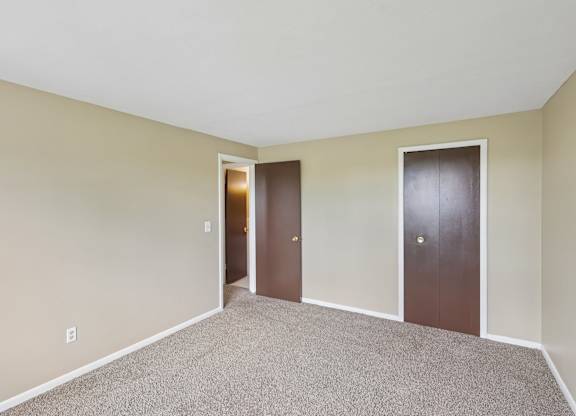 A room with two doors and a carpeted floor.