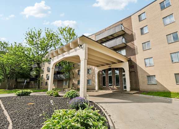 A building with a white archway entrance and a gravel area in front.