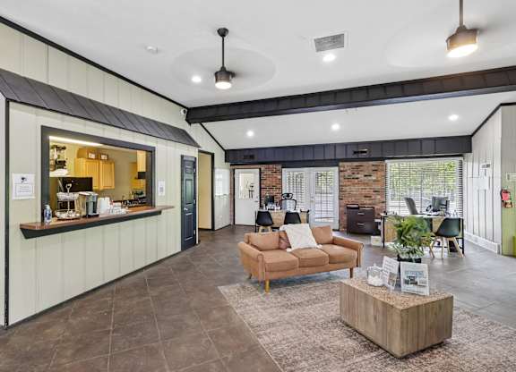 A modern living room with a brick wall and a bar area.