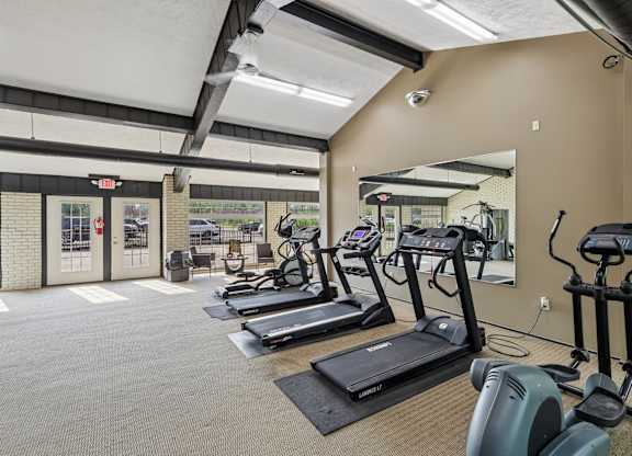 A gym with treadmills and elliptical machines.