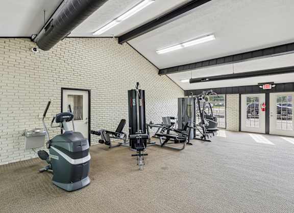 A gym with a variety of equipment including a treadmill, weights, and a stationary bike.