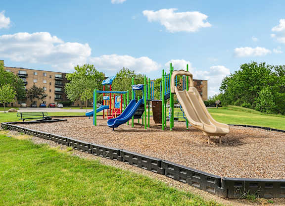 A playground with a blue slide and a yellow slide.