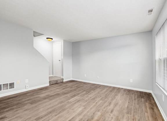 A room with wooden flooring and white walls.