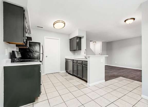 A kitchen with black appliances and white cabinets.