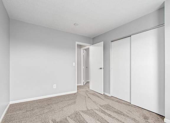 A room with a carpeted floor and white walls.