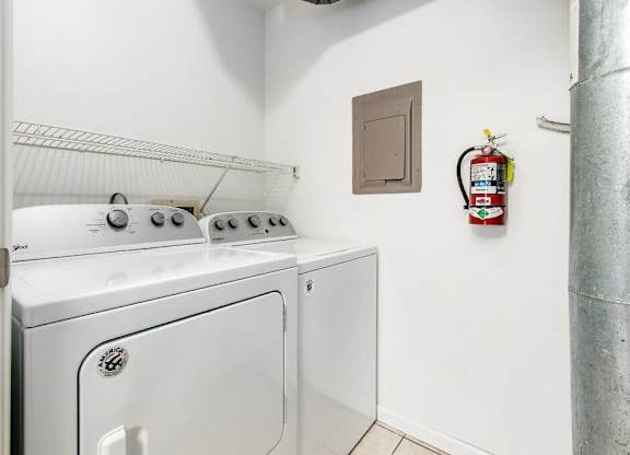 A white dryer and washer are in a small laundry room.