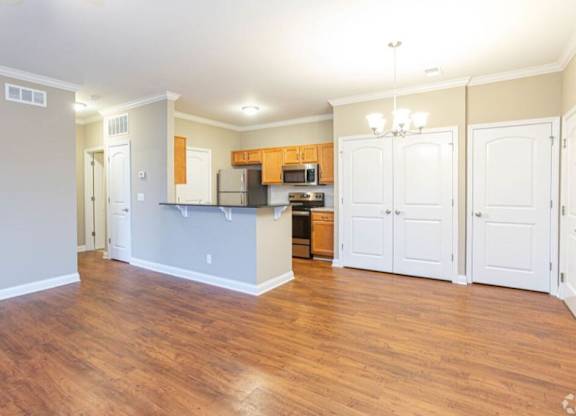 A kitchen with wooden floors and white walls.