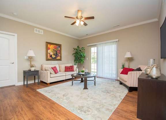 A living room with a couch, a coffee table, and a ceiling fan.