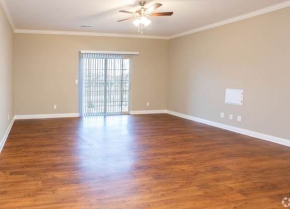 A room with wooden floors and a ceiling fan.