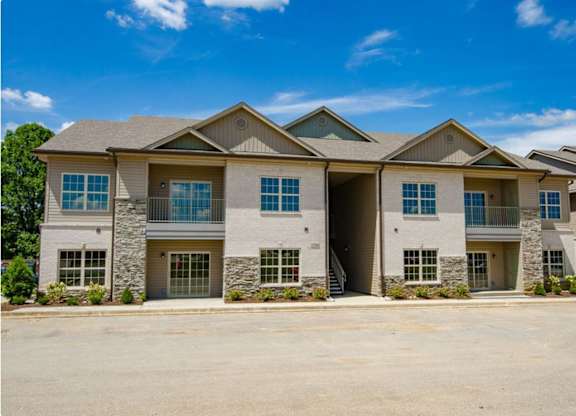 A large, modern house with a stone facade and multiple garage doors.