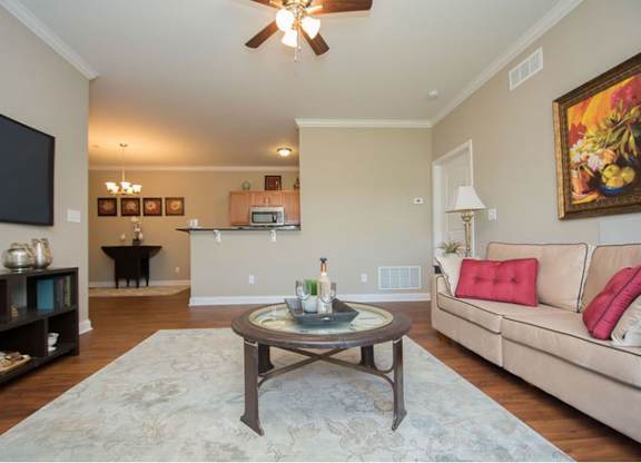 A living room with a couch, coffee table, and a ceiling fan.