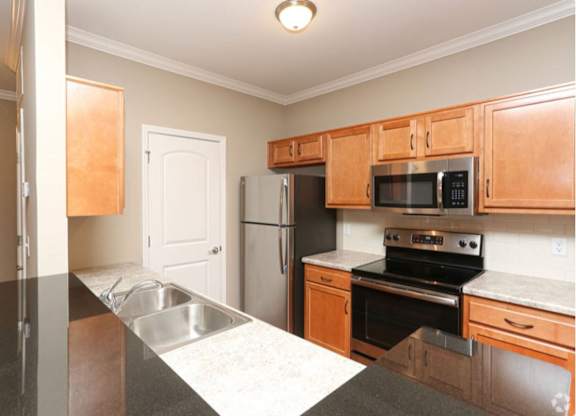 A kitchen with wooden cabinets and stainless steel appliances.