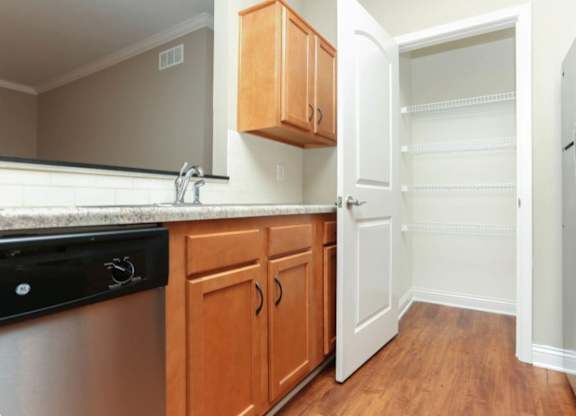 A kitchen with wooden cabinets and a black dishwasher.