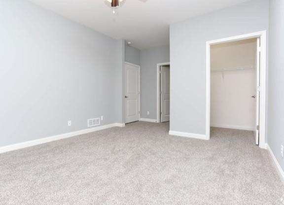 A spacious room with carpeted floor and white walls.