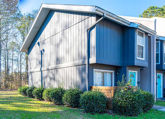A blue house with a white door and windows.