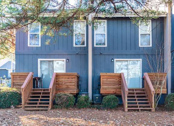 A blue house with wooden stairs leading to the front door.