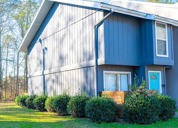 A blue house with a white door and windows.