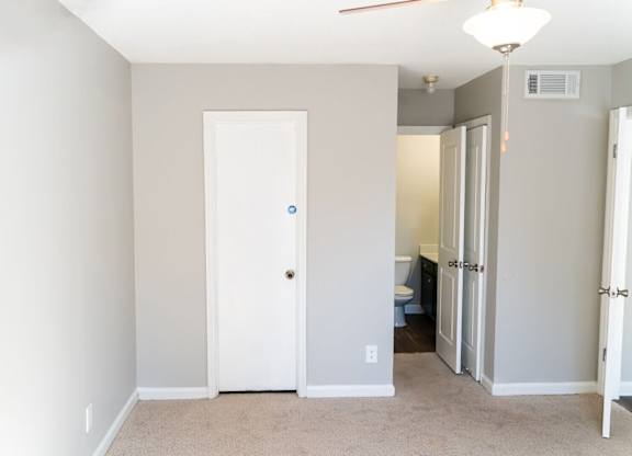 A white door is in a room with a carpet floor.