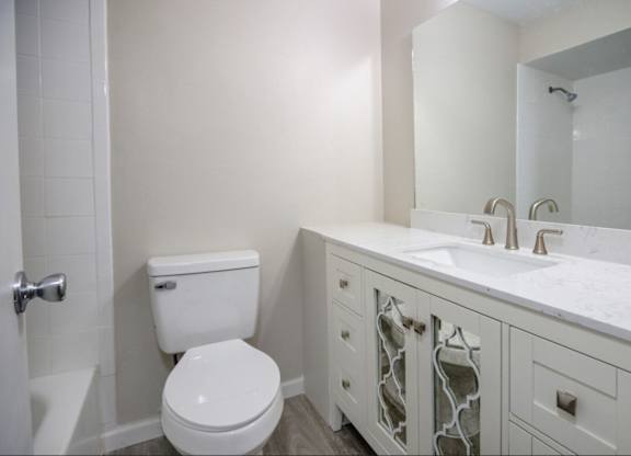 A white toilet sits next to a sink in a bathroom.