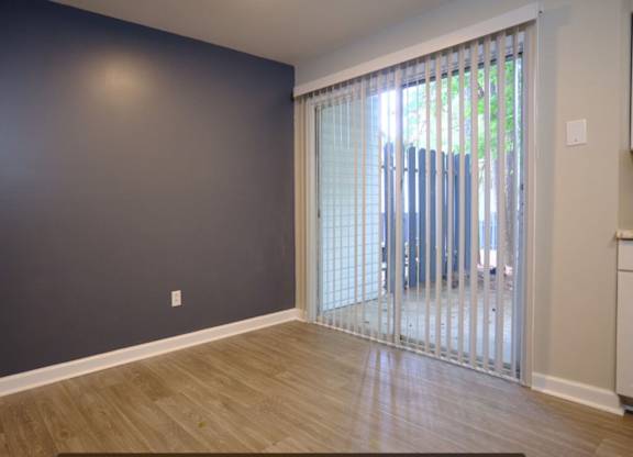 A room with a sliding glass door leading to a balcony.