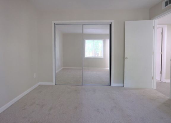 A room with a carpeted floor and a glass door.
