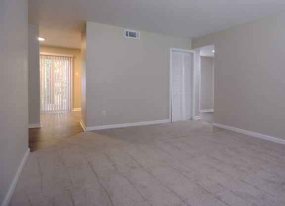 A room with a carpeted floor and a door.