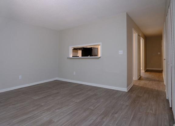 A room with a window and wooden flooring.