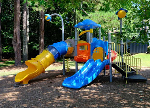 A playground with a blue and yellow slide.