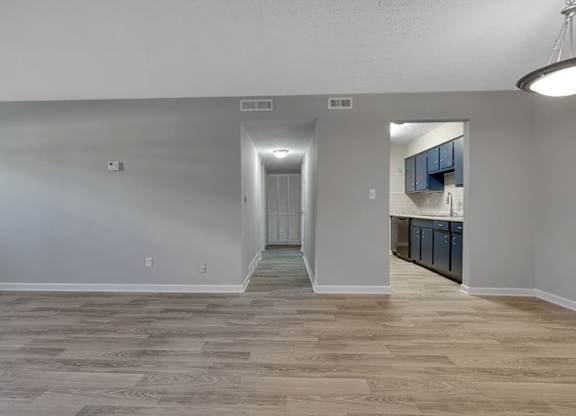 A room with wooden flooring and white walls.