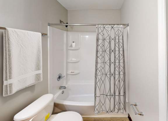 A white towel hangs on a towel rack in a bathroom.