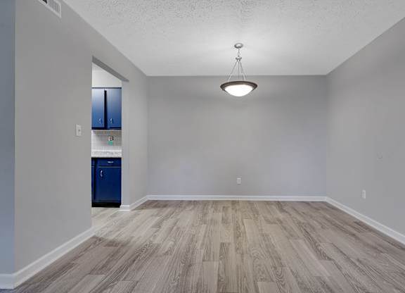 A room with a blue cabinet and wooden flooring.