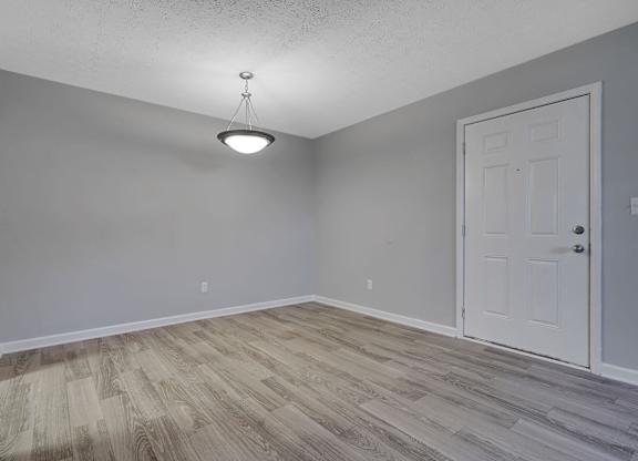 A room with a white door and a light hanging from the ceiling.