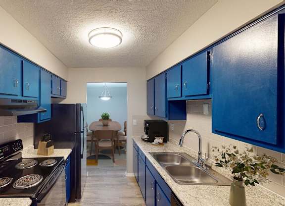 A kitchen with blue cabinets and a black stove top.