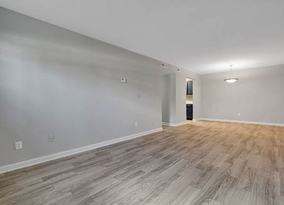 A room with wooden flooring and white walls.
