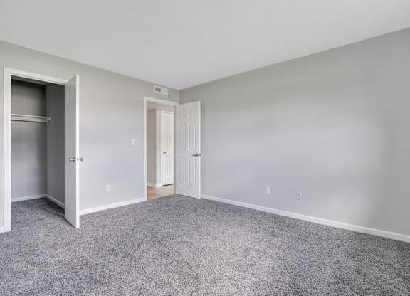 A room with a grey carpet and white walls.
