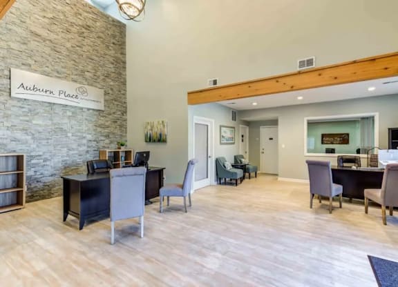 A living room with a stone wall and a sign that says Auburn Place.