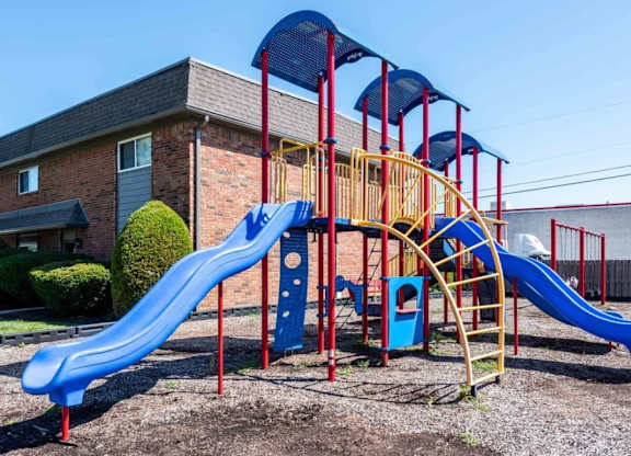 A playground with a blue slide and a yellow structure.