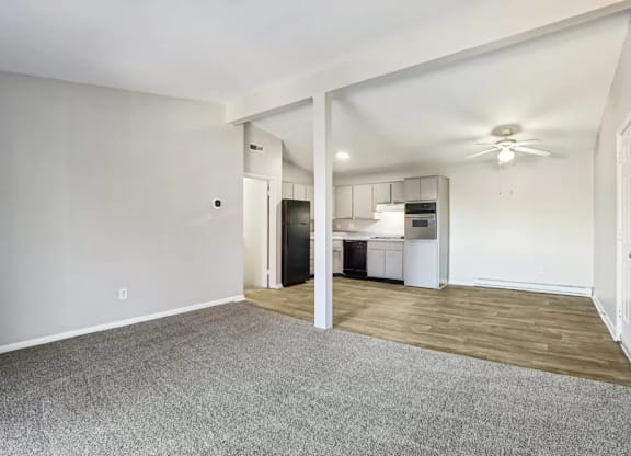 A spacious living room with a kitchen in the background.
